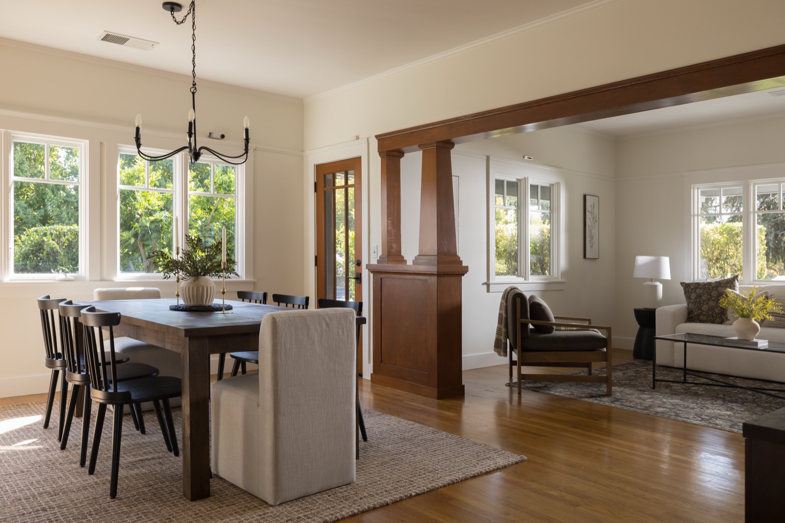 Dining room with chandelier, windows on two sides and wood Craftsman columns
