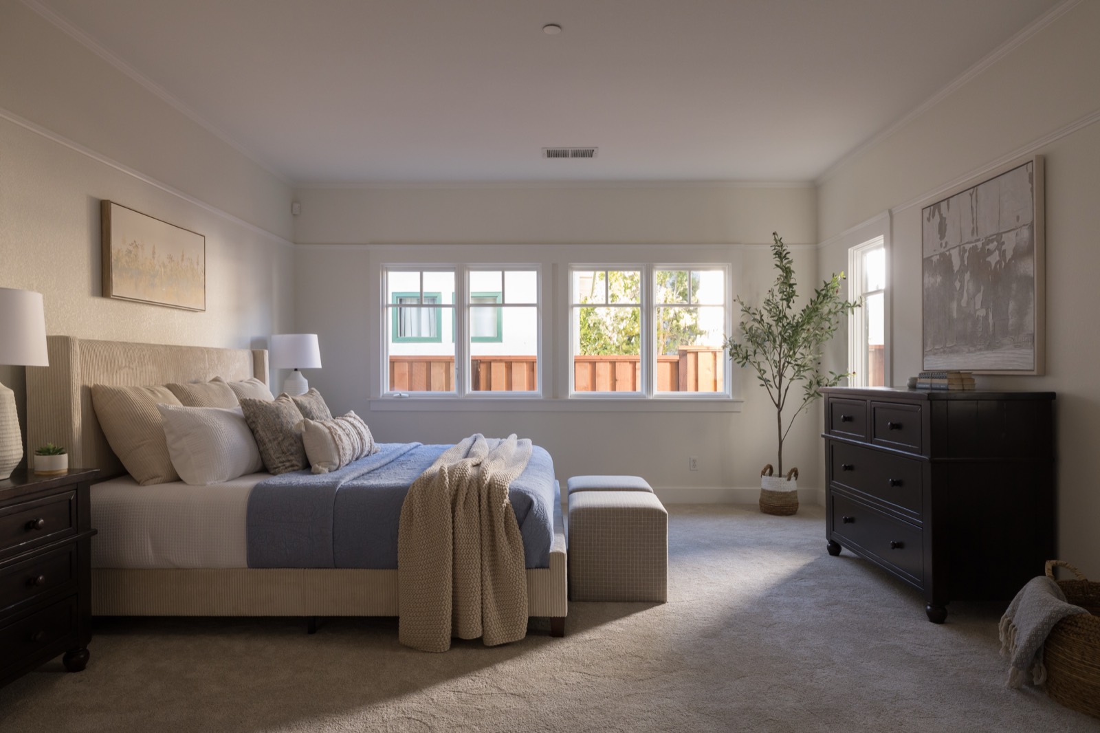 Primary bedroom with a row of windows and carpet